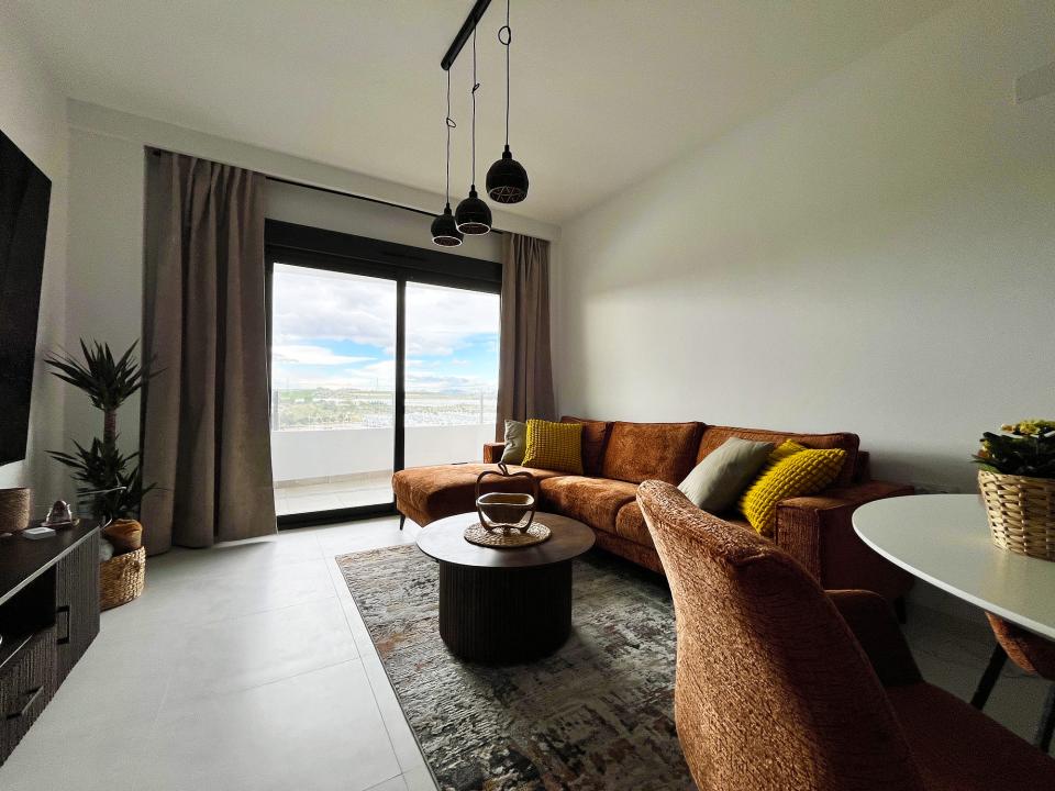 Obývací pokoj s&nbsp;plochou 98" TV, minibarem a&nbsp;Playstation 5